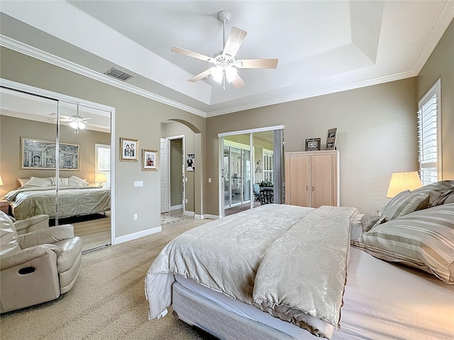 bedroom with access to exterior, ornamental molding, light colored carpet, a raised ceiling, and ceiling fan