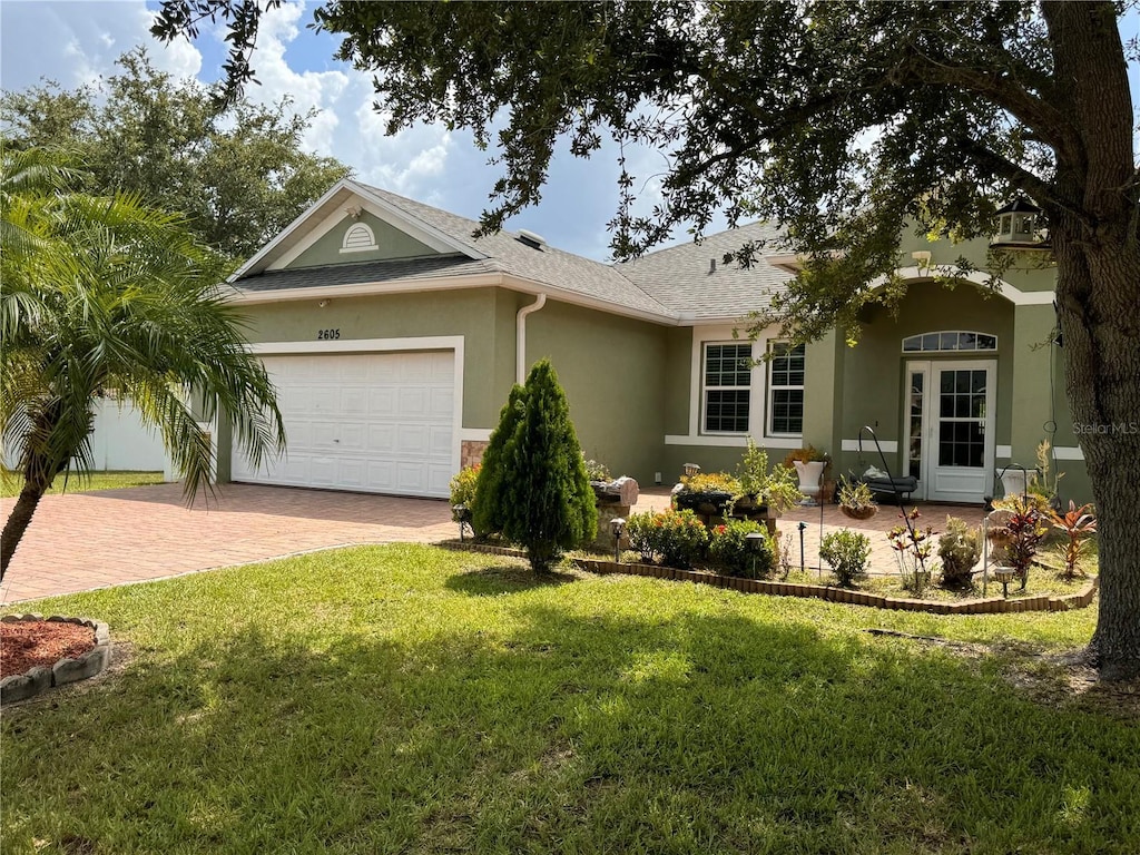 single story home featuring a garage and a front lawn