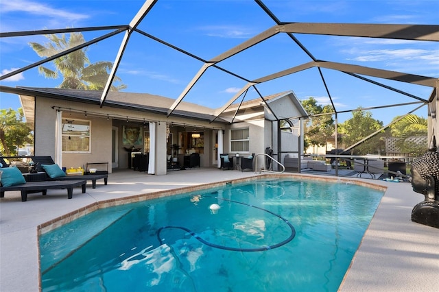 view of pool featuring a lanai, a patio area, and ceiling fan