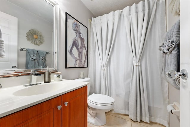 bathroom with tile patterned flooring, vanity, a textured ceiling, and toilet