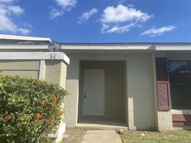 34 Pine Island Cir, Kissimmee, FL 34743 - view of exterior entry featuring stucco siding