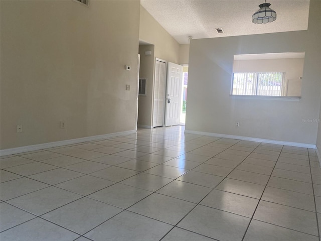 34 Pine Island Cir, Kissimmee, FL 34743 - unfurnished room with a textured ceiling, light tile patterned floors, and vaulted ceiling