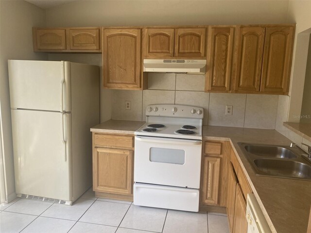 34 Pine Island Cir, Kissimmee, FL 34743 - kitchen with white appliances, under cabinet range hood, light tile patterned floors, and tasteful backsplash