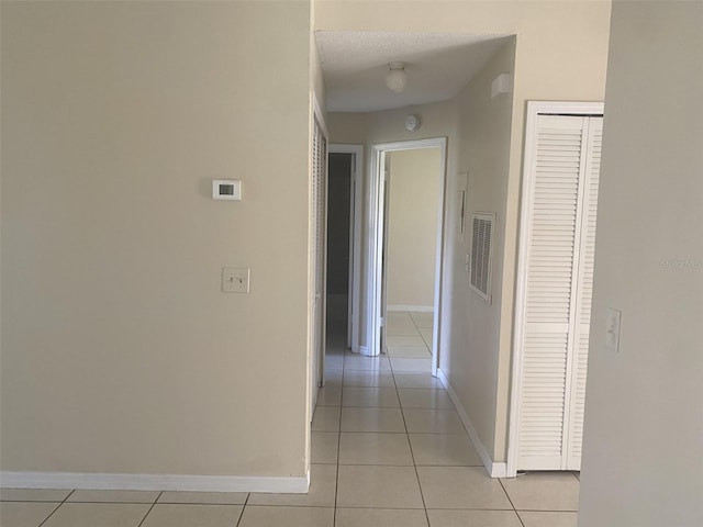 34 Pine Island Cir, Kissimmee, FL 34743 - corridor featuring light tile patterned floors and baseboards