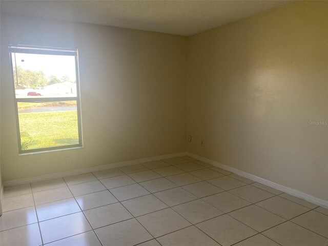 34 Pine Island Cir, Kissimmee, FL 34743 - empty room featuring healthy amount of natural light and light tile patterned floors
