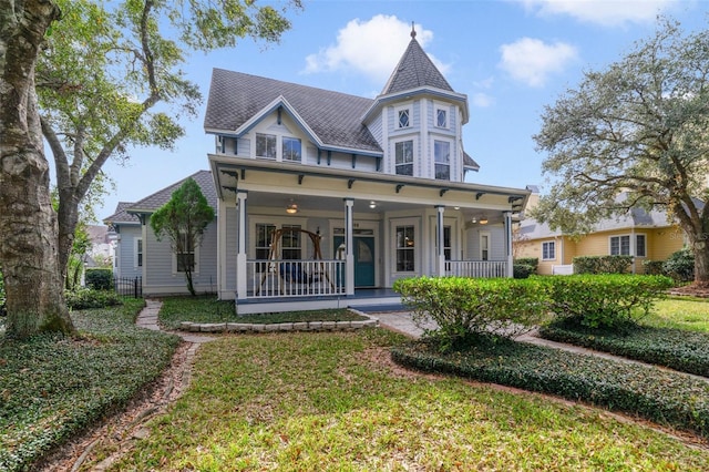 victorian-style house featuring a porch and a front yard