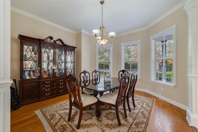 dining area featuring light hardwood / wood-style flooring, ornamental molding, and a notable chandelier