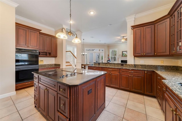 kitchen with a center island, hanging light fixtures, cooktop, black double oven, and ceiling fan with notable chandelier