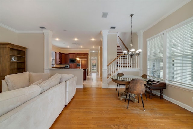 living room featuring crown molding, light hardwood / wood-style floors, and a notable chandelier