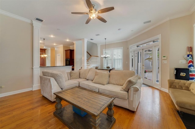 living room featuring ceiling fan with notable chandelier, light hardwood / wood-style floors, and ornamental molding