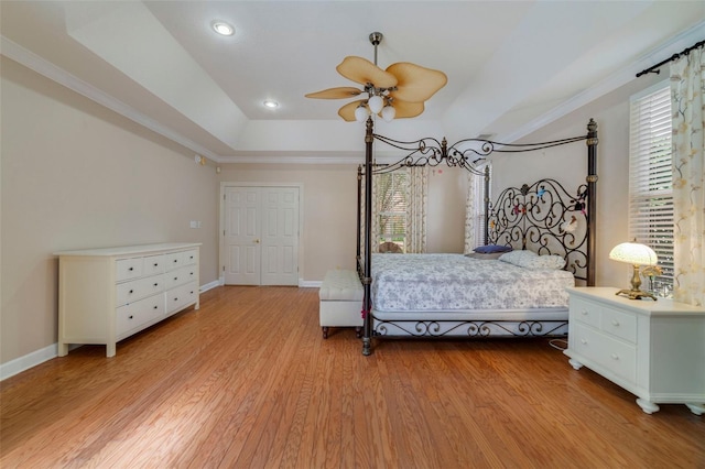 bedroom with multiple windows, ceiling fan, a closet, and light hardwood / wood-style floors