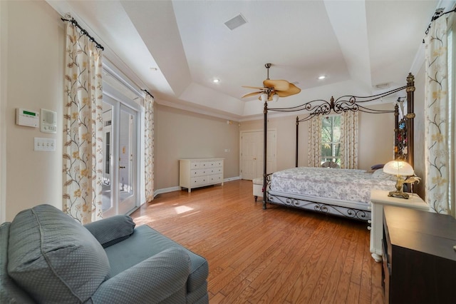 bedroom featuring a raised ceiling, ceiling fan, access to exterior, and wood-type flooring