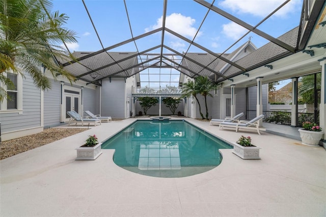 view of swimming pool with glass enclosure, an in ground hot tub, french doors, and a patio