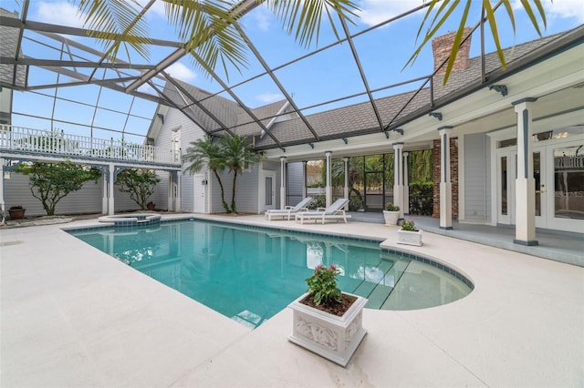 view of swimming pool with glass enclosure, a patio area, and an in ground hot tub