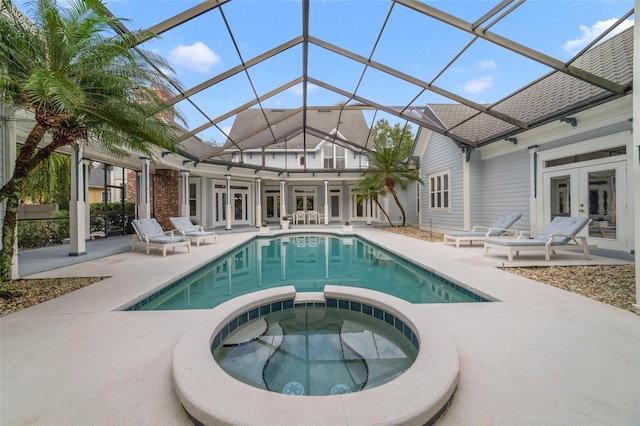 view of swimming pool featuring an in ground hot tub, french doors, a patio, and glass enclosure