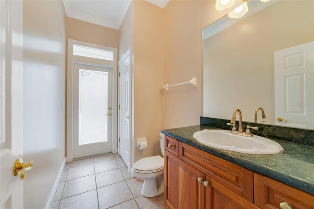 bathroom with tile patterned flooring, vanity, toilet, and ornamental molding