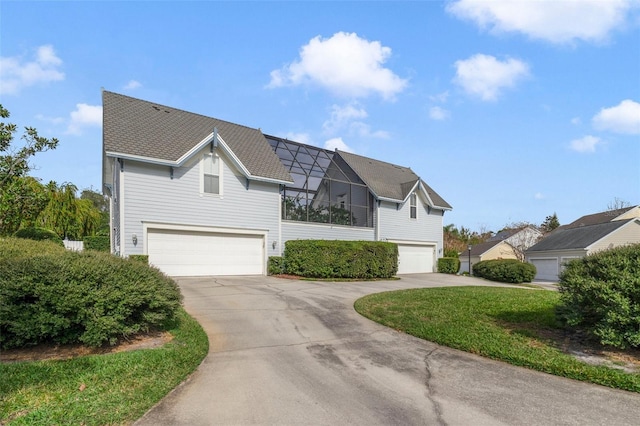 view of property featuring glass enclosure, a garage, and a front yard