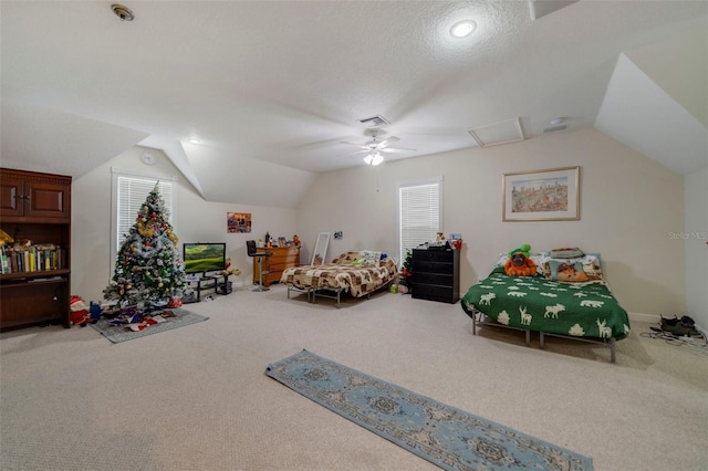 bedroom with carpet, a textured ceiling, vaulted ceiling, and ceiling fan