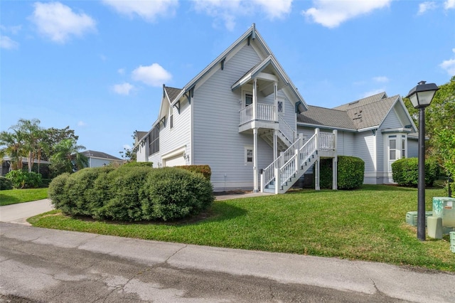 view of front of house with a balcony, a garage, and a front lawn