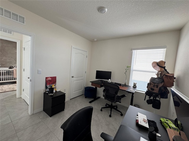 tiled office space featuring a textured ceiling