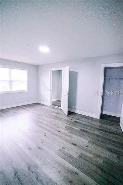 spare room featuring a textured ceiling and dark hardwood / wood-style floors