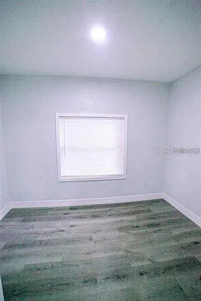 unfurnished room featuring dark wood-type flooring