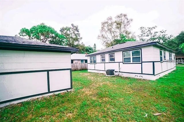 rear view of house with a lawn and central AC