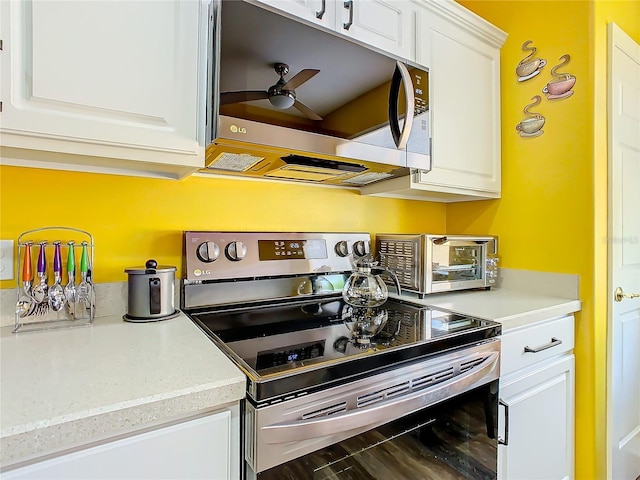 kitchen featuring ceiling fan, wood-type flooring, white cabinetry, and appliances with stainless steel finishes