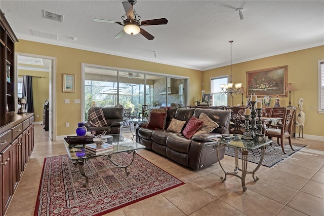 living room featuring ceiling fan with notable chandelier, crown molding, light tile patterned floors, and a textured ceiling