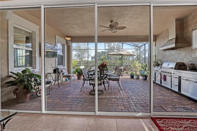 sunroom / solarium with ceiling fan and sink