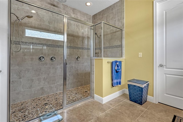 bathroom with tile patterned floors and a tile shower