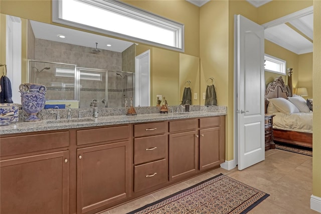 bathroom featuring tile patterned flooring, vanity, a wealth of natural light, and a shower with shower door