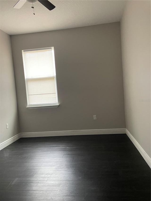 unfurnished room with dark hardwood / wood-style floors and ceiling fan