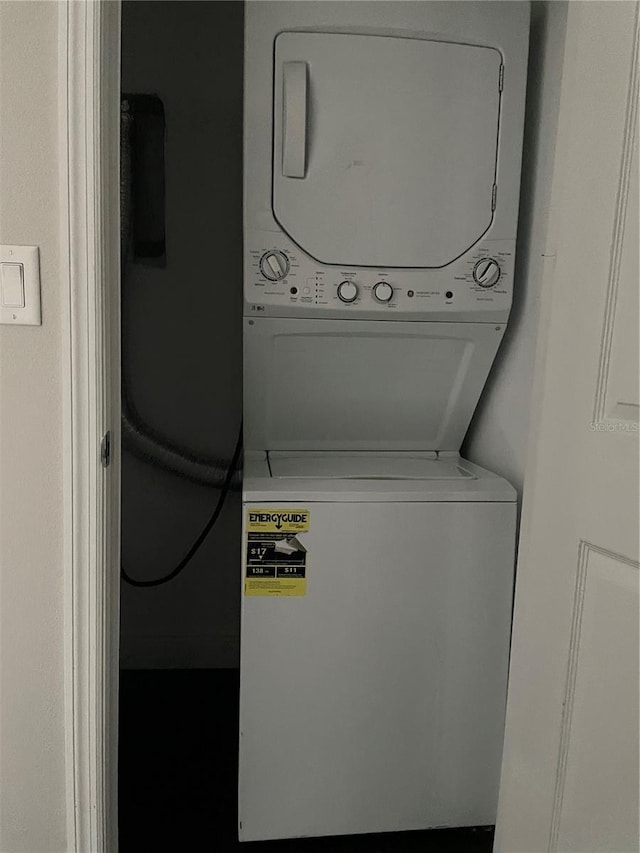 clothes washing area featuring stacked washing maching and dryer