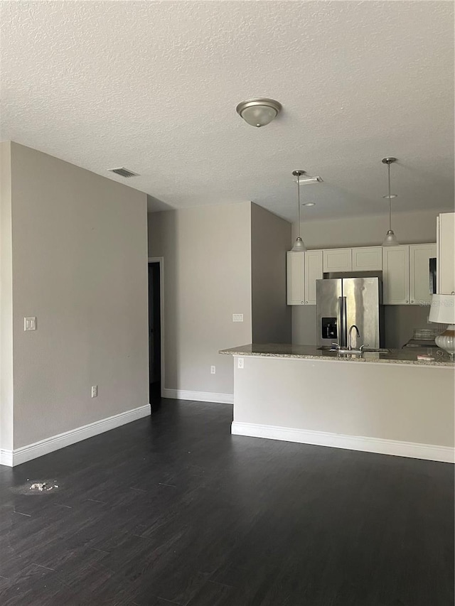 kitchen featuring decorative light fixtures, kitchen peninsula, white cabinets, and stainless steel refrigerator with ice dispenser