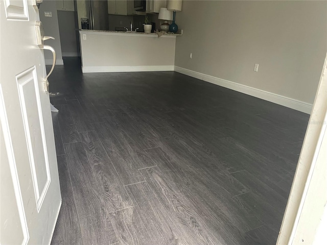 unfurnished living room with dark hardwood / wood-style flooring