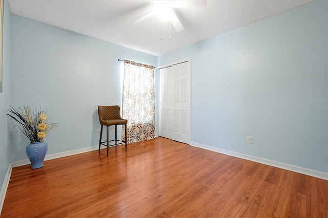 spare room featuring ceiling fan, hardwood / wood-style floors, and a textured ceiling