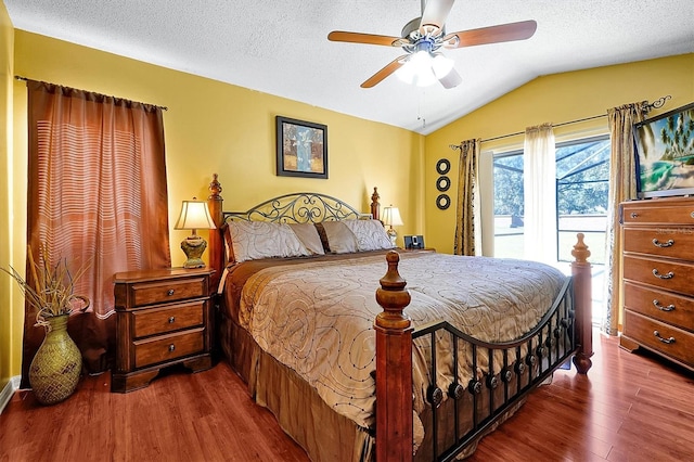 bedroom featuring hardwood / wood-style floors, lofted ceiling, access to outside, ceiling fan, and a textured ceiling