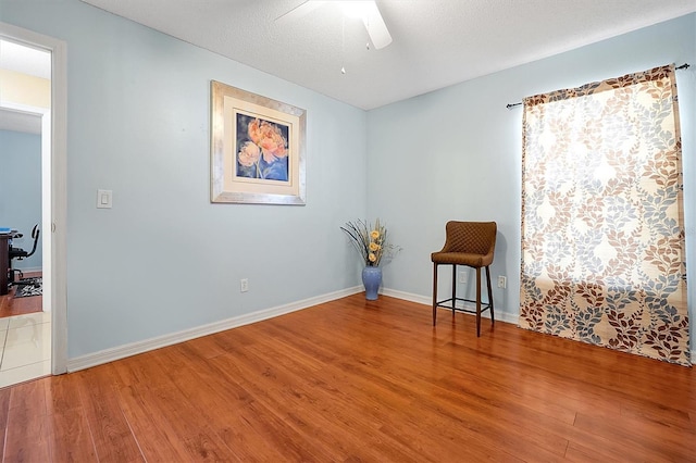 unfurnished room featuring wood-type flooring, a textured ceiling, and ceiling fan