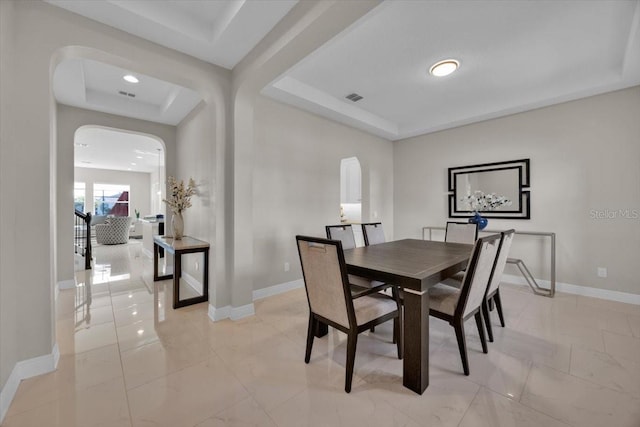 dining space with a raised ceiling