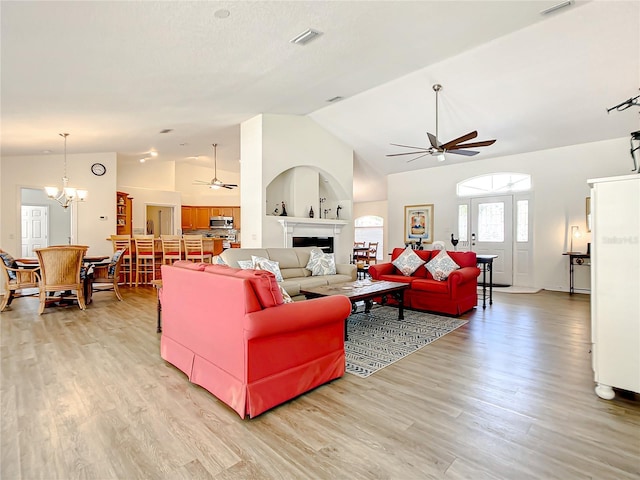 1281 N Timucuan Trl, Inverness, FL 34453 - living room featuring ceiling fan with notable chandelier, light wood-type flooring, and high vaulted ceiling