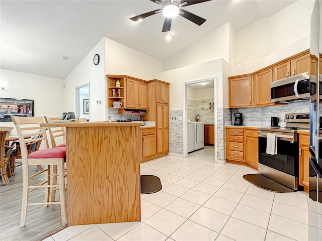 1281 N Timucuan Trl, Inverness, FL 34453 - kitchen with a kitchen bar, appliances with stainless steel finishes, tasteful backsplash, vaulted ceiling, and light tile patterned flooring