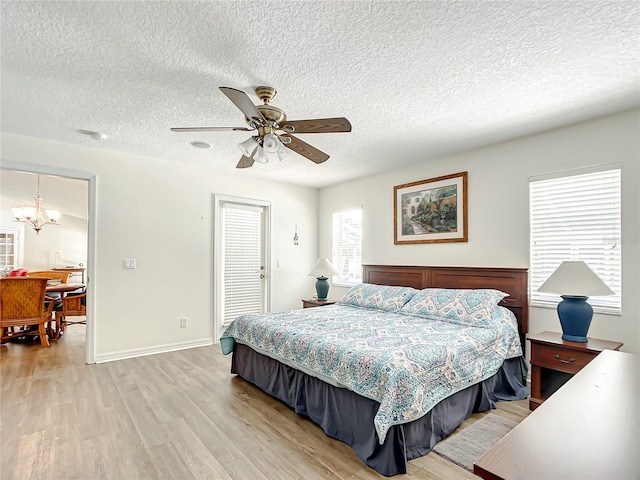 1281 N Timucuan Trl, Inverness, FL 34453 - bedroom with light wood-type flooring, a textured ceiling, and ceiling fan with notable chandelier