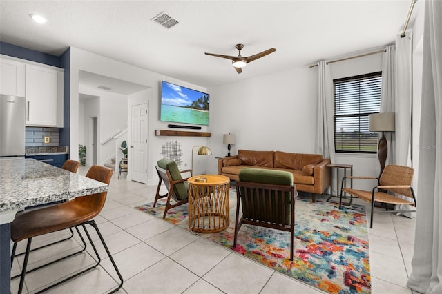 tiled living room featuring ceiling fan