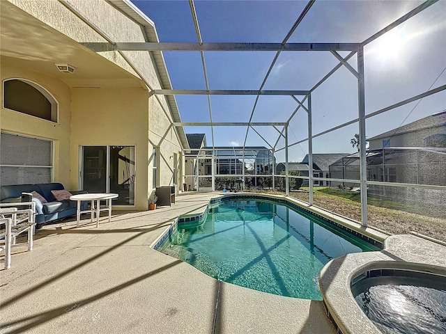 view of pool with glass enclosure, a patio area, and an in ground hot tub