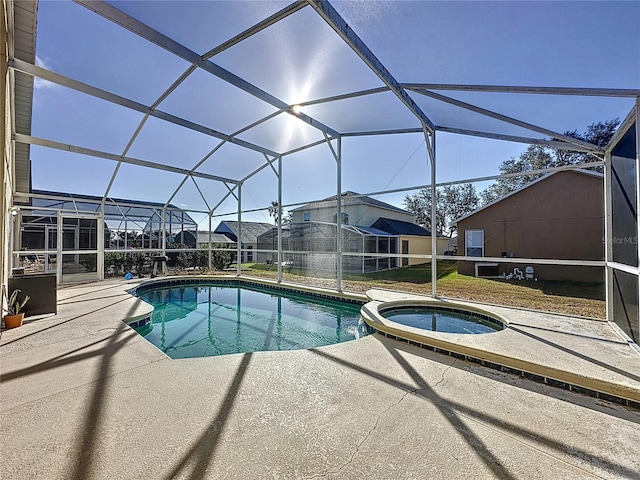 view of pool featuring an in ground hot tub, a patio, and glass enclosure