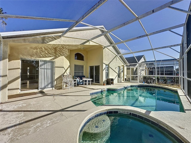 rear view of house featuring glass enclosure, a patio area, and a pool with hot tub