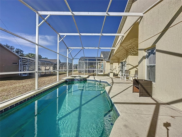 view of swimming pool featuring a patio area, a lanai, and an in ground hot tub