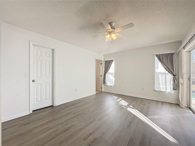 unfurnished room featuring ceiling fan, dark hardwood / wood-style flooring, and a textured ceiling