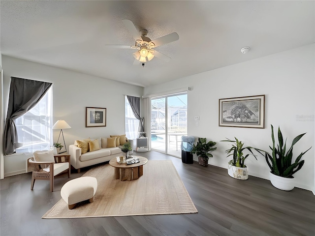 living room featuring ceiling fan and dark hardwood / wood-style floors